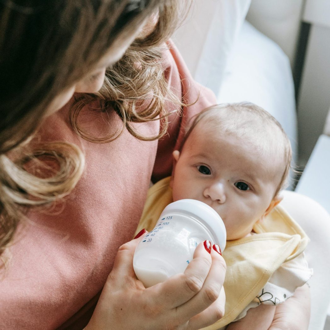 pexels-sarah-chai-7282910 Photo by Sarah Chai: https://www.pexels.com/photo/cute-newborn-drinking-milk-from-bottle-in-hands-of-crop-mom-7282910/